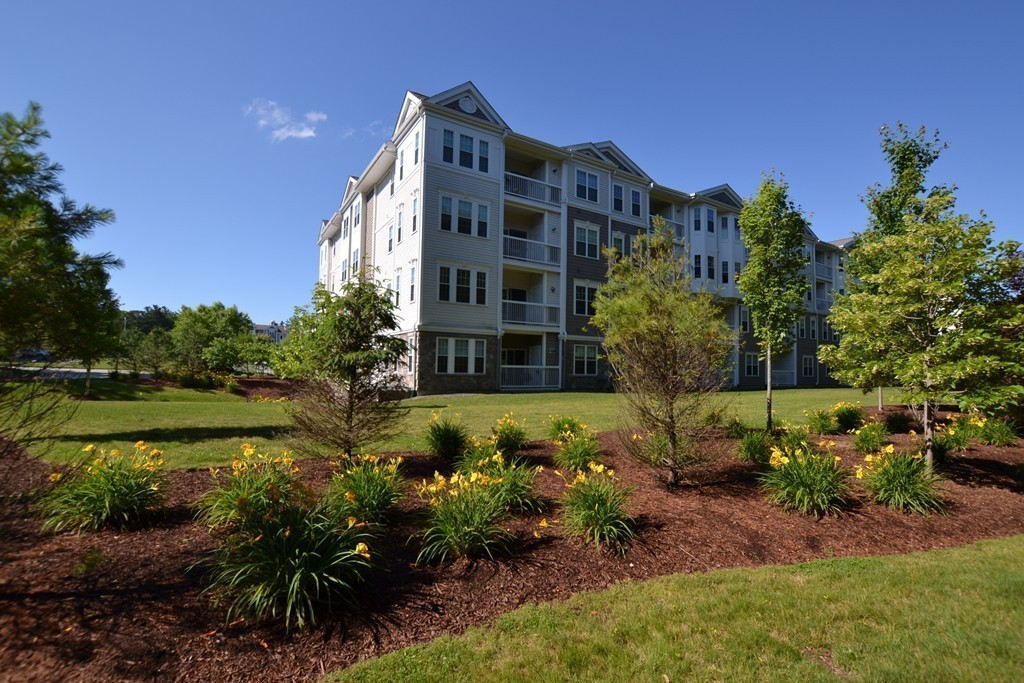 7 Augustus Court, Unit 1013 Reading, MA 01867 - Photo 4 of 34 a view of a large building with a yard and large trees