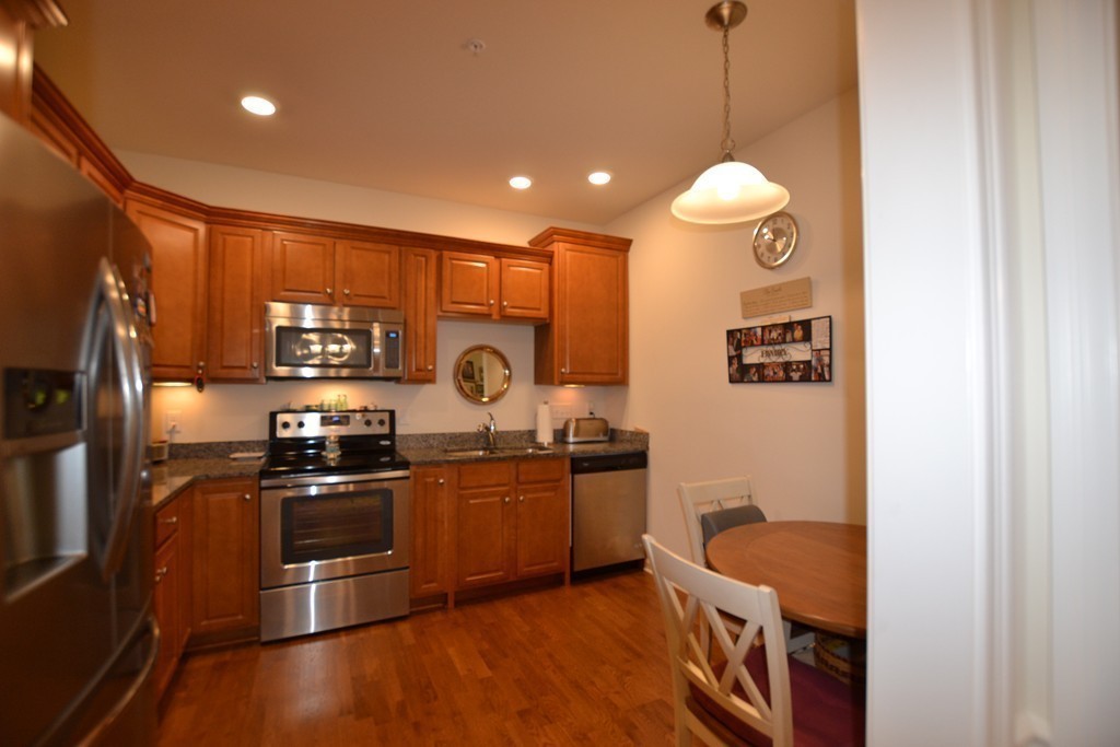 7 Augustus Court, Unit 1013 Reading, MA 01867 - Photo 6 of 34 a kitchen with stainless steel appliances granite countertop a sink stove and refrigerator