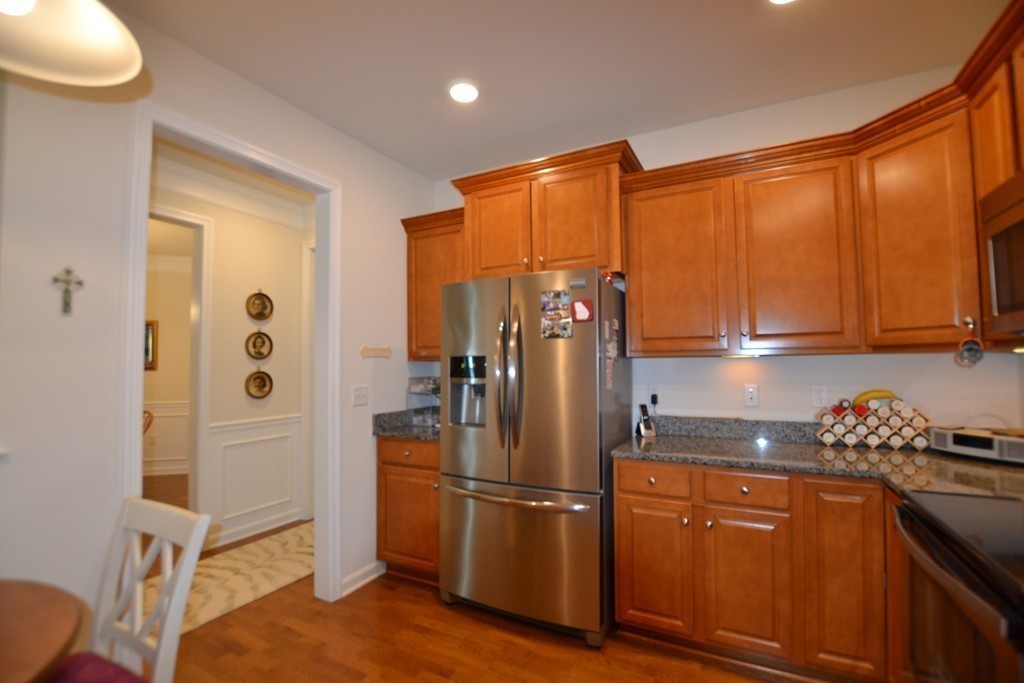 7 Augustus Court, Unit 1013 Reading, MA 01867 - Photo 7 of 34 a kitchen with stainless steel appliances granite countertop a refrigerator a stove and a sink with wooden cabinets