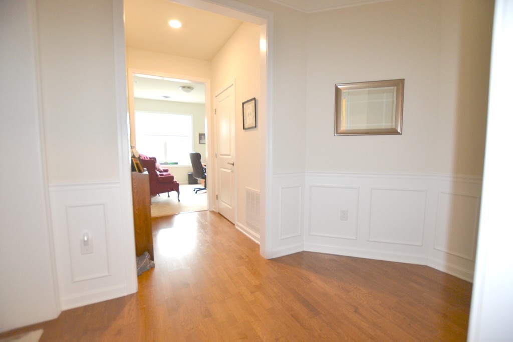 7 Augustus Court, Unit 1013 Reading, MA 01867 - Photo 10 of 34 a view of a hallway with wooden floor and a bathroom