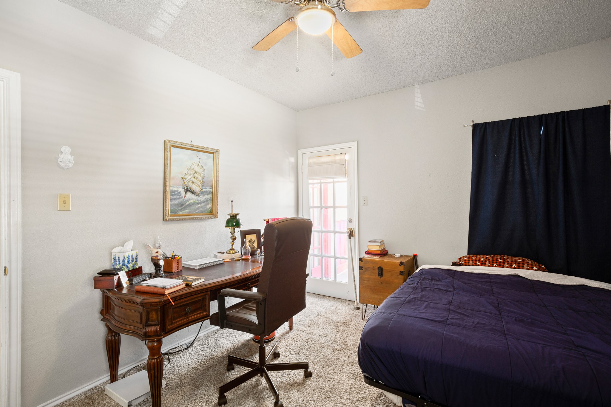 706 West 22nd Street, Unit 206 Austin, TX 78705 - Photo 9 of 18 Bedroom featuring carpet floors, an office area, a ceiling fan, and a textured ceiling