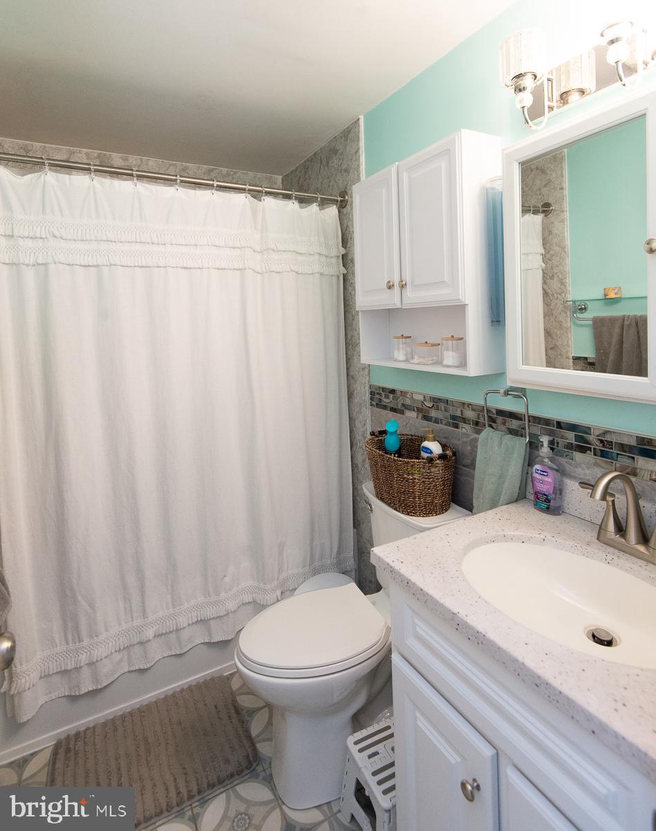 12 North Maple Avenue Ridgely, MD 21660 - Photo 25 of 30 a bathroom with a sink a toilet and shower curtain