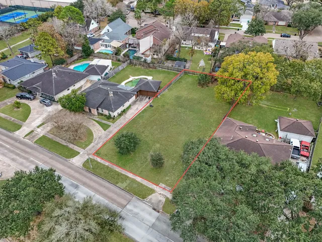 an aerial view of residential houses with outdoor space and swimming pool