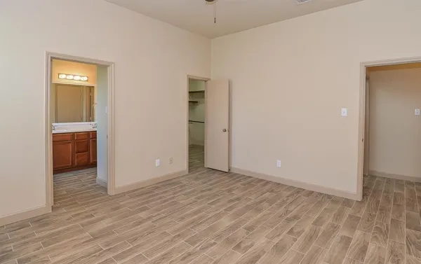 a view of an empty room with closet and a window