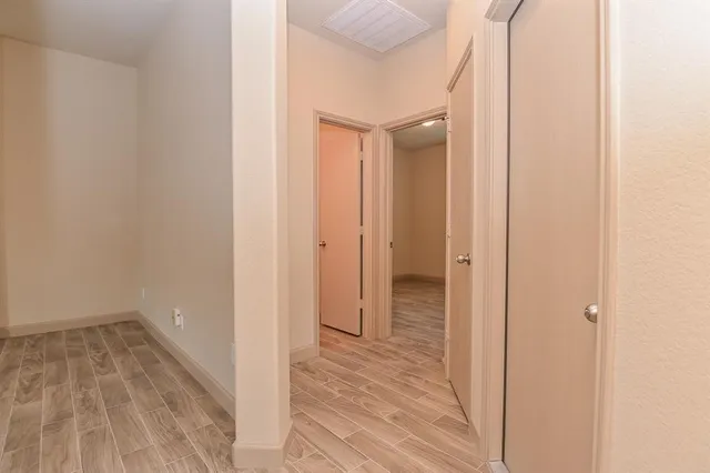 a view of a room with wooden floor and a bathroom