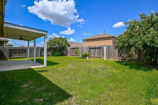 a view of a house with backyard and a tree