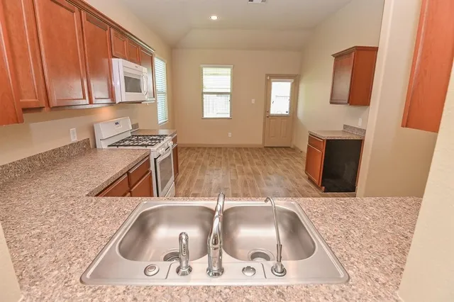 a kitchen with a sink a stove and cabinets