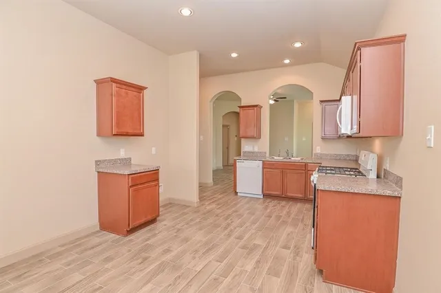 a large kitchen with stainless steel appliances granite countertop a stove a sink and a refrigerator