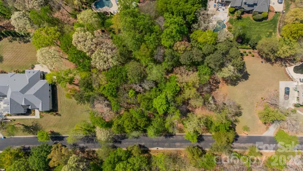 an aerial view of residential houses with outdoor space and trees