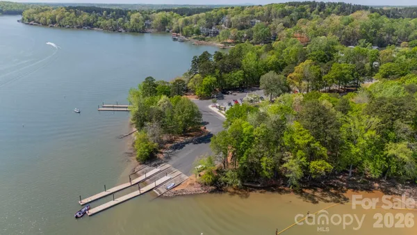 an aerial view of a house with a yard and lake view