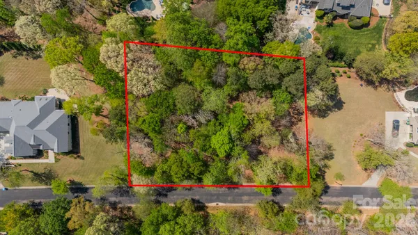 an aerial view of residential house with outdoor space and trees all around