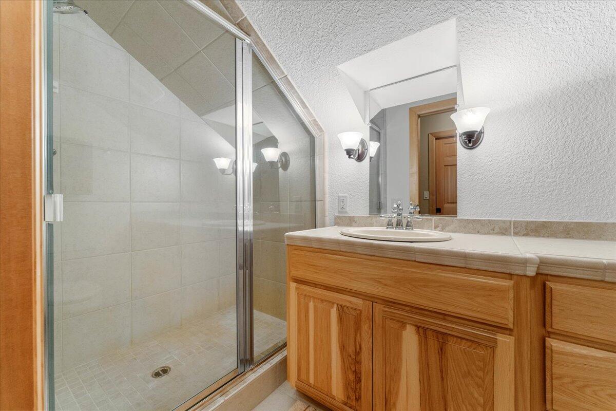 1601 Timber Hills Road Mount Shasta, CA 96067 - Photo 28 of 74 a bathroom with a granite countertop sink a mirror and shower
