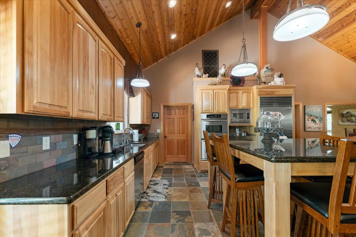 1601 Timber Hills Road Mount Shasta, CA 96067 - Photo 32 of 74 a kitchen with stainless steel appliances kitchen island granite countertop a stove and cabinets