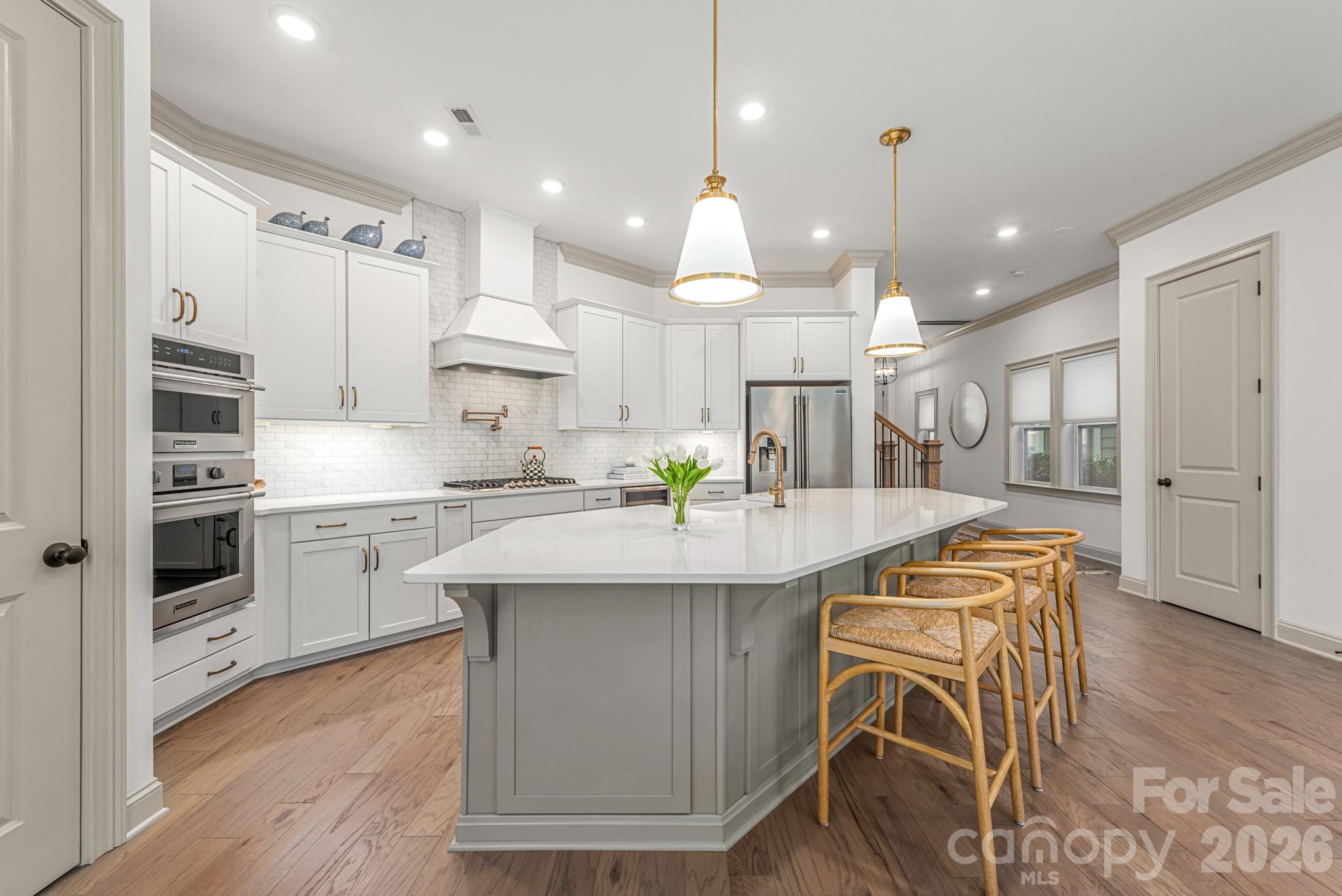 2547 Barry Street Charlotte, NC 28205 - Photo 14 of 45 a kitchen with stainless steel appliances kitchen island granite countertop a sink a stove a refrigerator and island with wooden floor