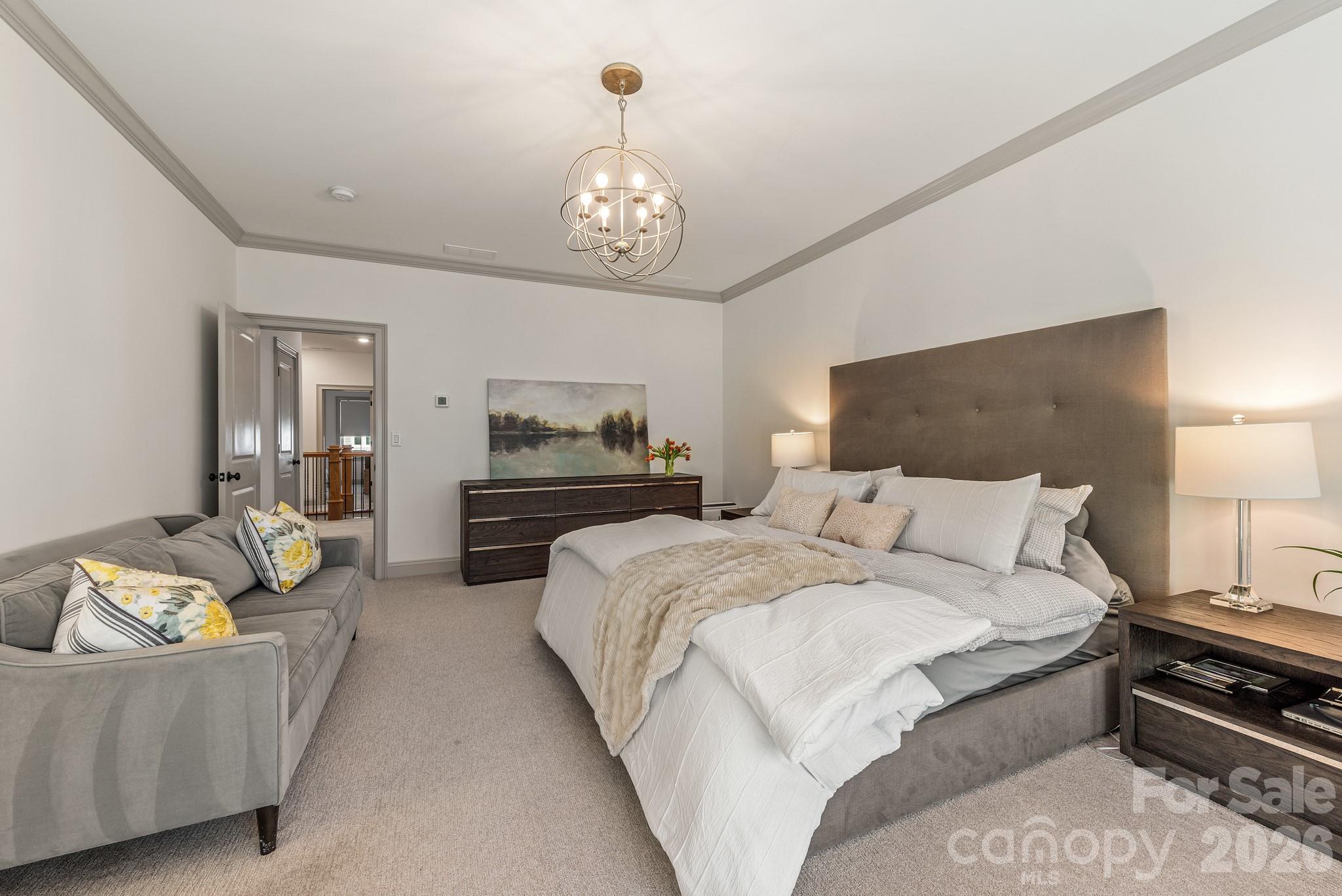 2547 Barry Street Charlotte, NC 28205 - Photo 29 of 45 a spacious bedroom with a bed and a chandelier