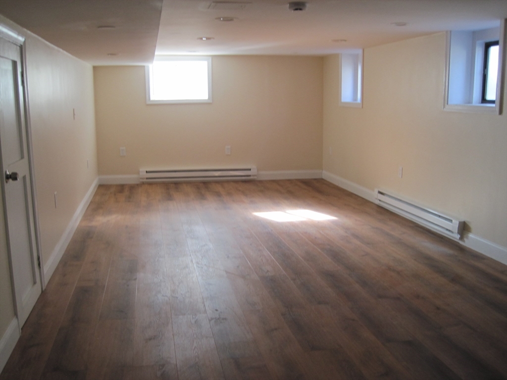 139 Readville Street Boston, MA 02136 - Photo 25 of 31 an empty room with wooden floor and windows