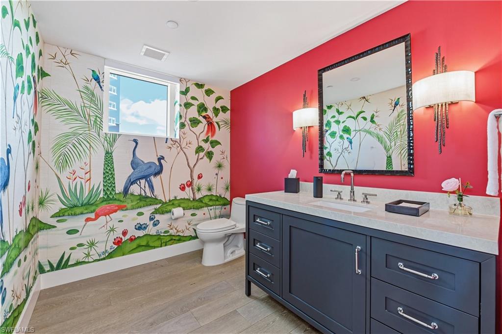 13935 Old Coast Road, Unit 406 Naples, FL 34110 - Photo 14 of 49 Bathroom with vanity, light wood-style floors, and an accent wall