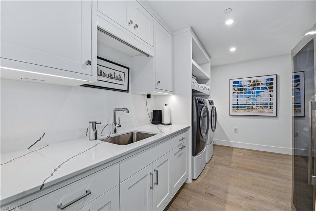 13935 Old Coast Road, Unit 406 Naples, FL 34110 - Photo 19 of 49 Laundry area with light wood-style flooring, washing machine and dryer, and recessed lighting