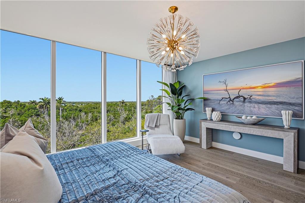 13935 Old Coast Road, Unit 406 Naples, FL 34110 - Photo 21 of 49 Bedroom featuring hanging lights and wood finished floors
