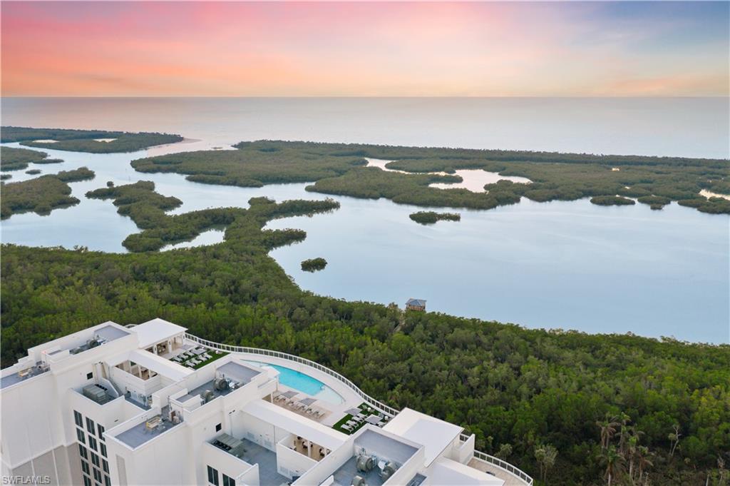 13935 Old Coast Road, Unit 406 Naples, FL 34110 - Photo 32 of 49 Aerial view at dusk of a forest view and a water view