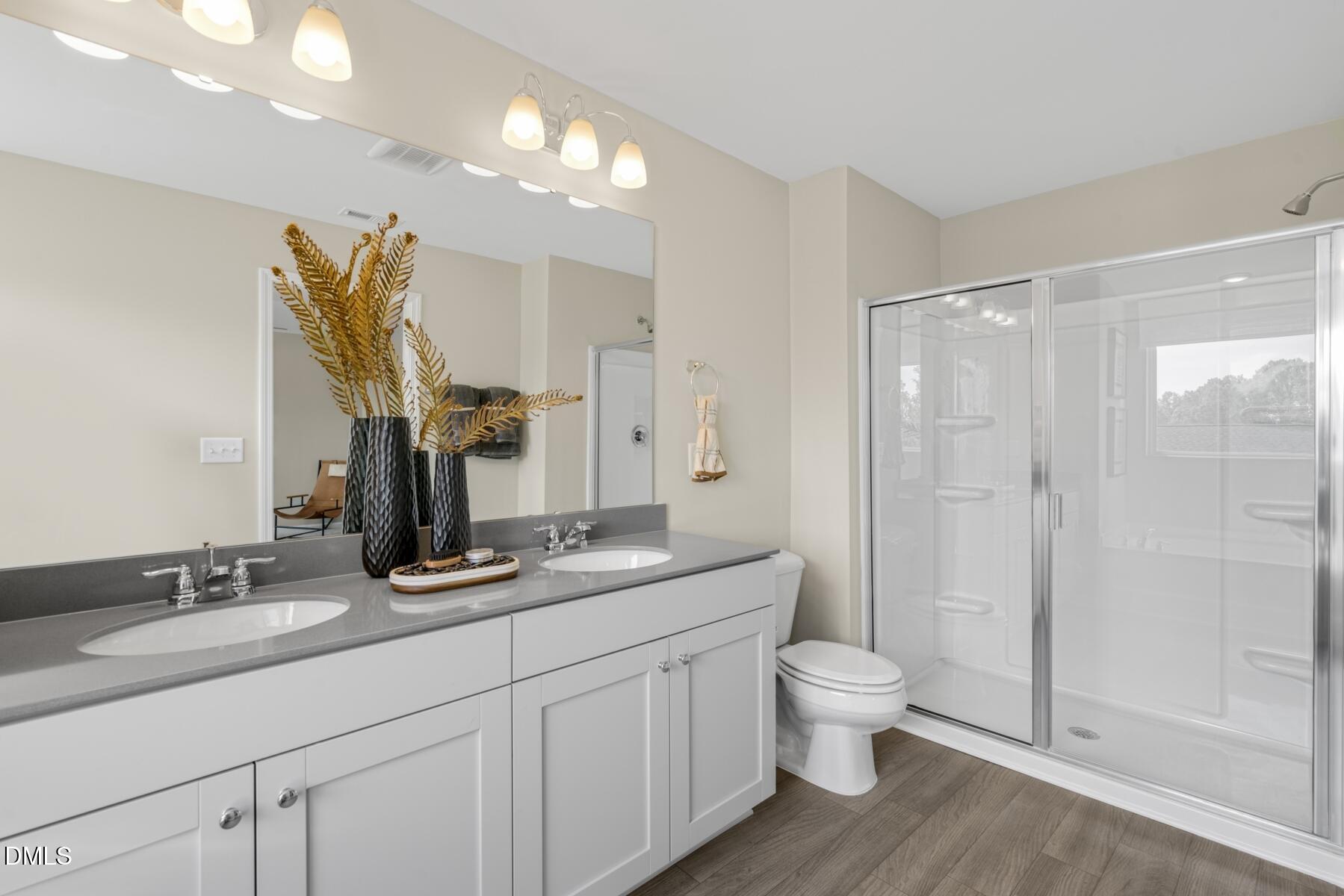 128 Lennei Lane Garner, NC 27529 - Photo 22 of 30 a bathroom with a double vanity sink toilet and shower