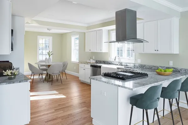 a kitchen with a stove a table and chairs in it