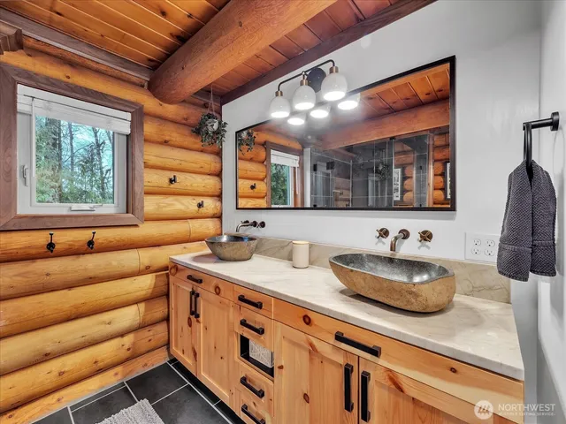 a bathroom with a granite countertop sink mirror and window