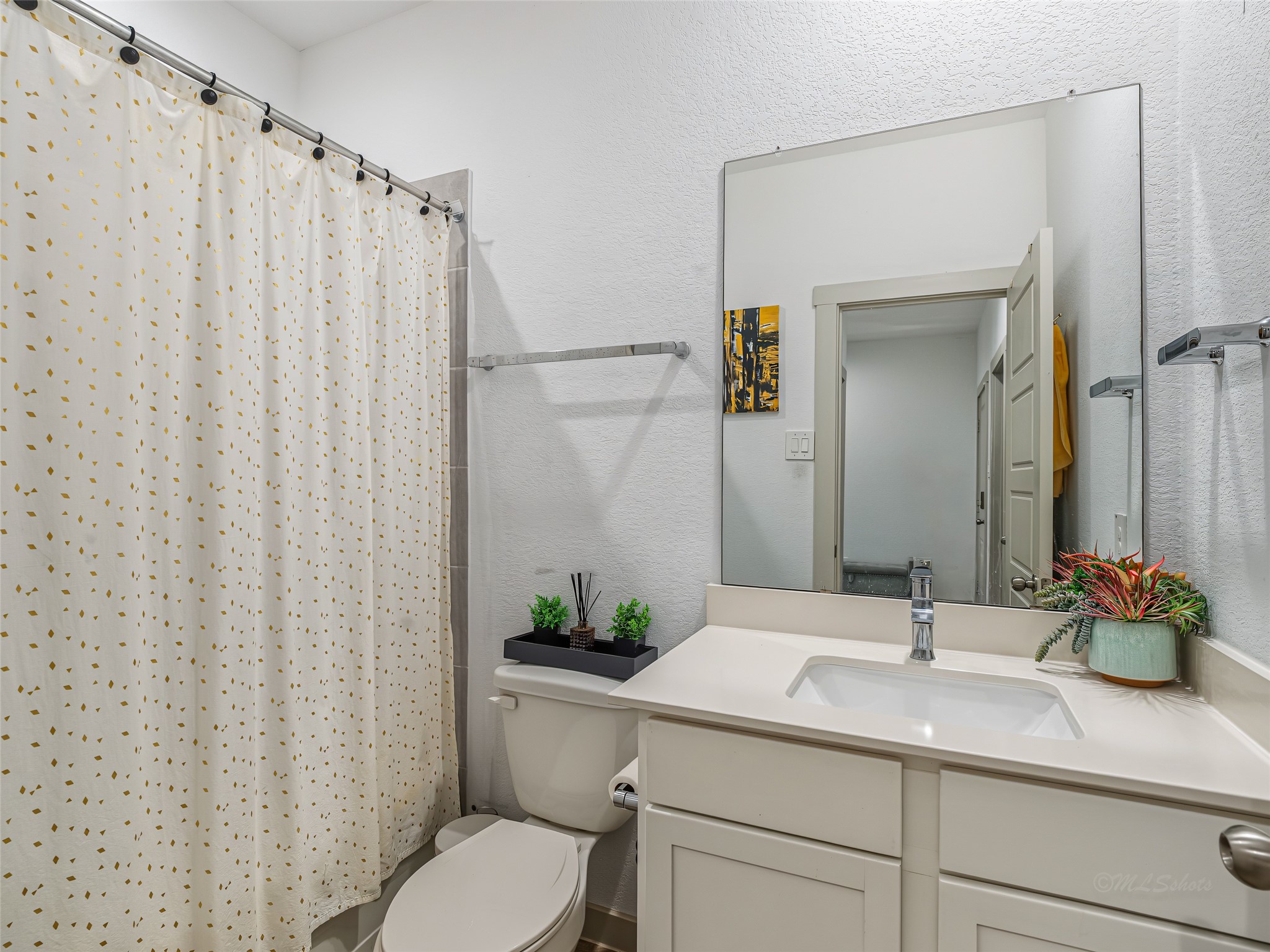 8043 Milam Lane Rosharon, TX 77583 - Photo 7 of 41 This bright bathroom features a pristine white vanity with an undermount sink, providing plenty of smooth countertop space and hidden cabinet storage underneath. A massive, frameless wall mirror expands the room visually, catching the excellent lighting. Shower/tub combo convenient for your overnight guests