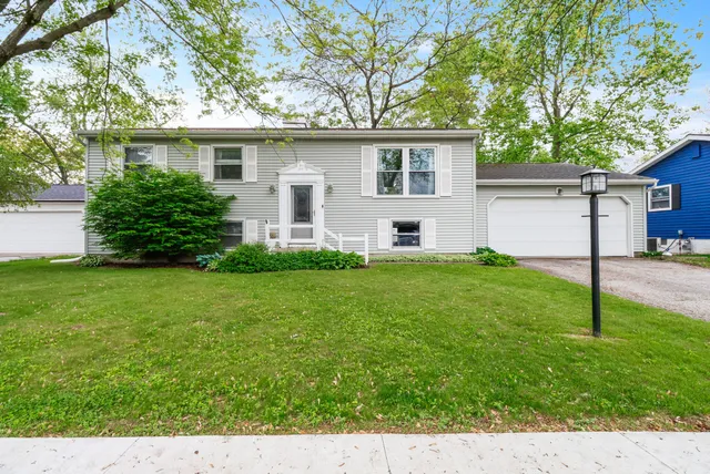 a view of a house with a yard and tree