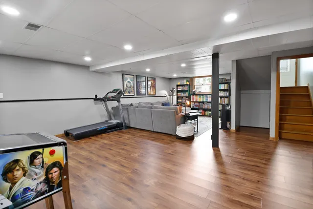 a living room with stainless steel appliances furniture and a wooden floor