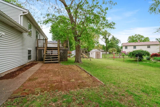 a view of a house with backyard and a tree