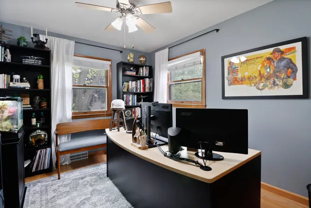 a work room with furniture a bookshelf and a window