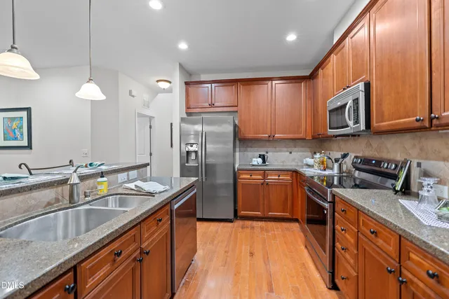 a kitchen with stainless steel appliances granite countertop a sink stove and refrigerator
