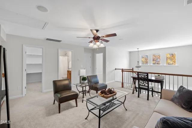 a living room with furniture a chandelier and a rug