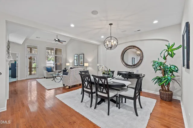 a living room with furniture a clock potted plant and a large window