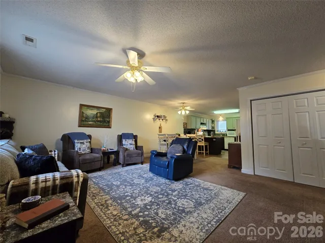a living room with furniture a dining table and kitchen view