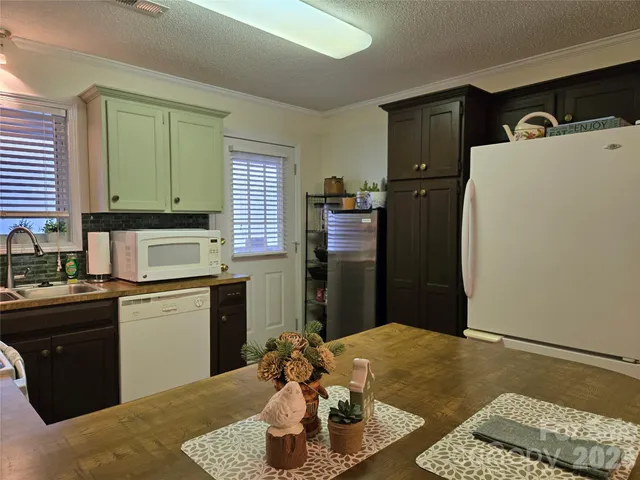 a kitchen with a refrigerator and a stove top oven