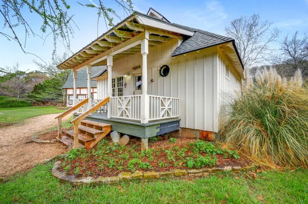 a view of a house with a small yard and sitting area
