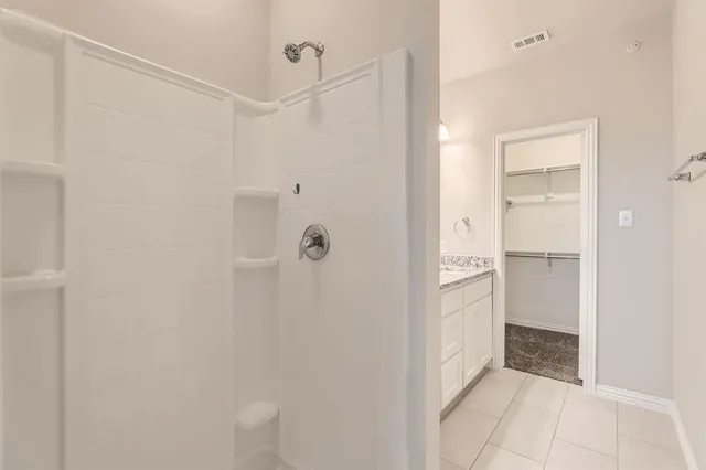 a bathroom with a shower and a glass door