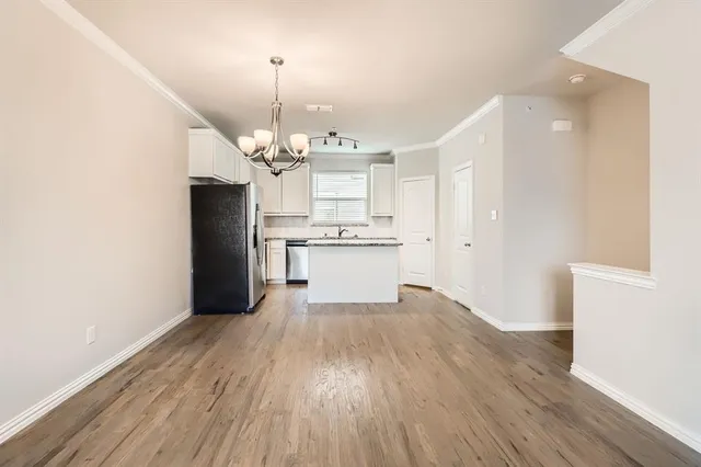 a view of a kitchen with wooden floor and stainless steel appliances