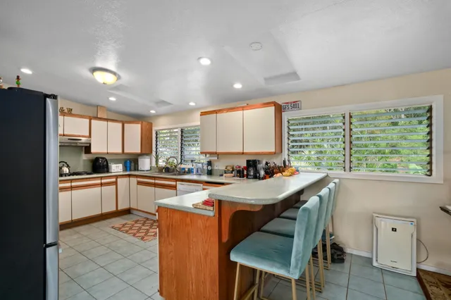 a kitchen with a table chairs refrigerator and cabinets