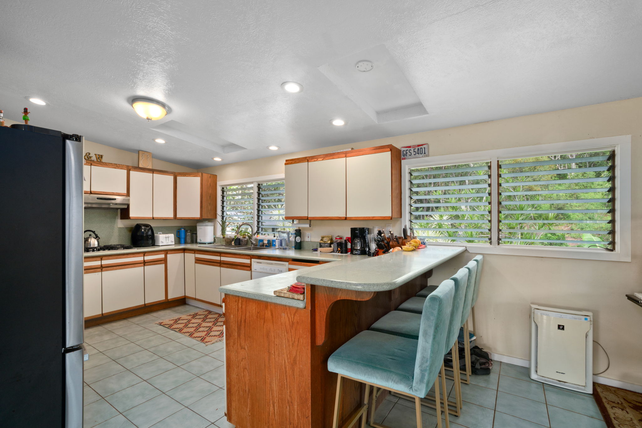 4906 Aliali Road Kapaa, HI 96746 - Photo 3 of 30 a kitchen with a table chairs refrigerator and cabinets