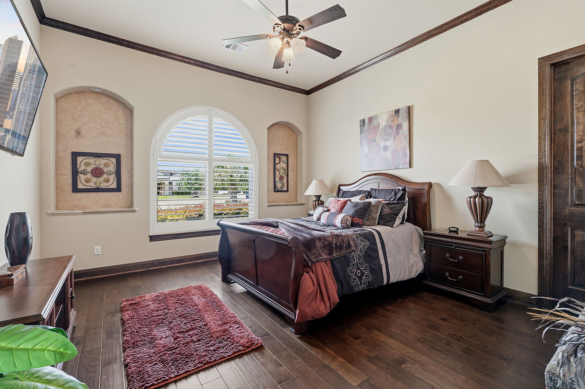 816 Brave Face Street Leander, TX 78641 - Photo 25 of 40 Rich hardwood floors complement a spacious bedroom featuring crown molding and an elegant arched window.