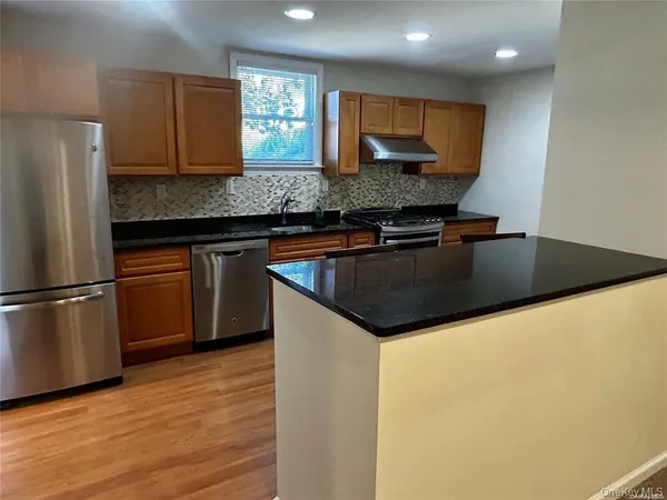 a kitchen with stainless steel appliances granite countertop a sink stove and refrigerator