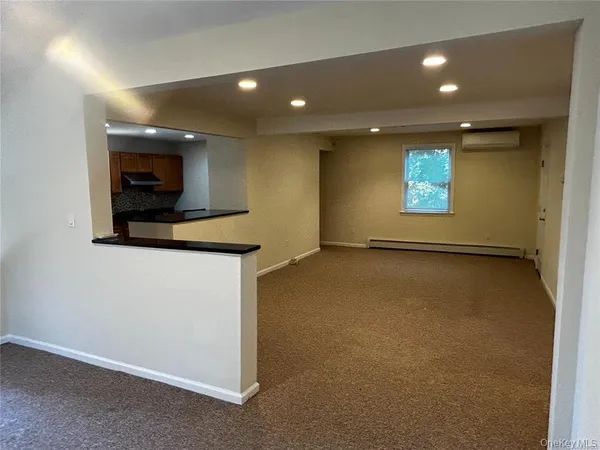 a view of an empty room with a fireplace and a window