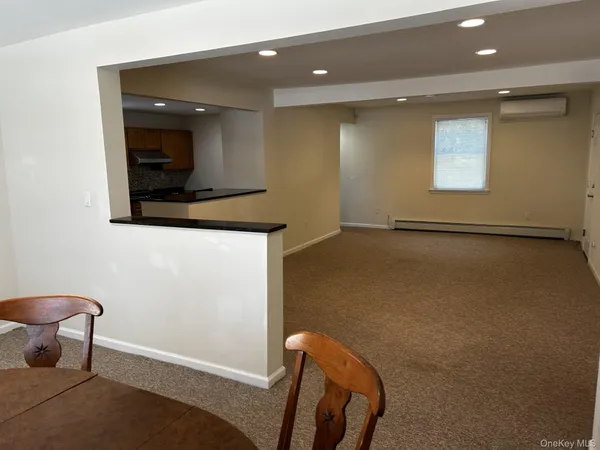 an empty room with windows & lounge chair