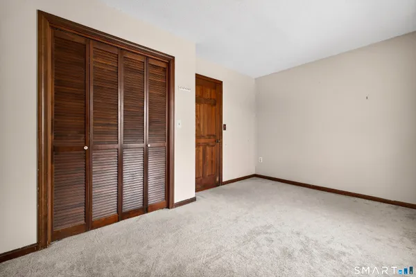 an empty room with windows and closet