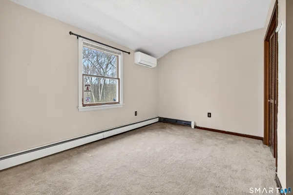 an empty room with a chandelier fan and windows
