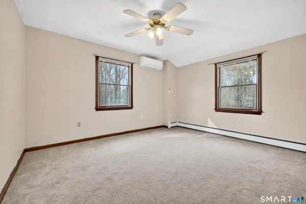 an empty room with windows and fan