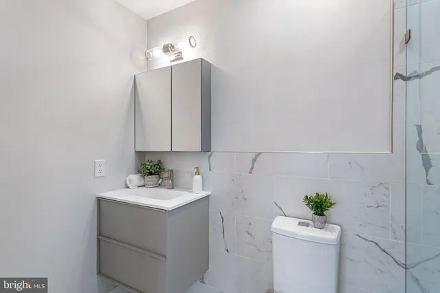 a bathroom with a sink toilet and a mirror